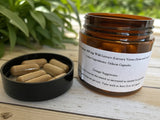 Amber glass jar with a label containing  Wild Lettuce herbal capsules on a wooden surface with wild lettuce in the background.