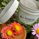 Bentonite Clay container with flowers on a wooden surface