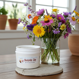 Bentonite Clay container on a wooden surface with a vase of colorful flowers in the background.